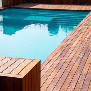 Piscine moderne avec liner bleu clair, entourée d'une terrasse et d'une structure en bois exotique, invitant à la détente.
